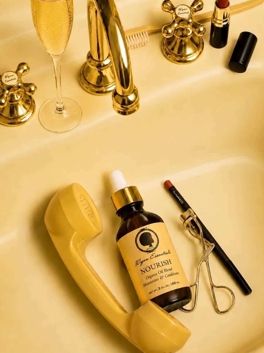 Wynn Essentials Nourish oil in a gold editorial vanity flat lay
